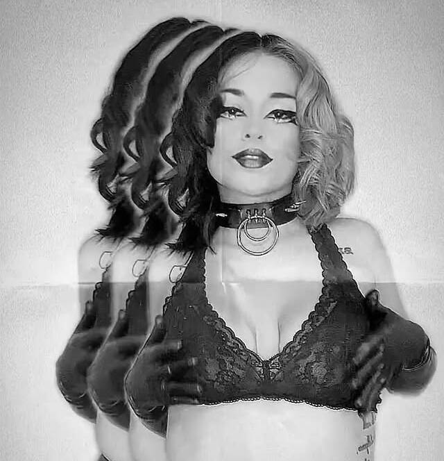 Black and white photo of a woman in a lace bralette and choker with a double exposure effect creating overlapping poses